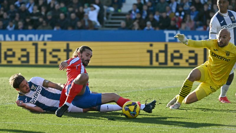 El delantero francés del Atlético de Madrid, Antoine Griezmann, remata ante la humanidad del portero serbio del Leganés, Marko Dmitrovic.