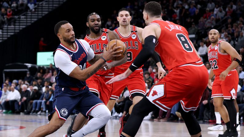 Norman Powell de los LA Clippers conduce hacia la canasta frente a Zach LaVine, Patrick Williams y Nikola Vucevic de los Chicago Bulls.