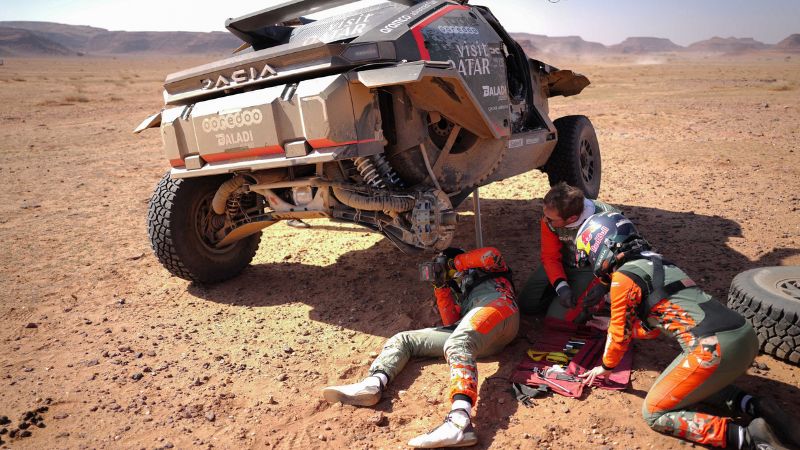 El piloto qatarí Nasser Al-Attiyah y el navegante francés Edouard Boulanger reparan su Dacia Sandrider durante la etapa 4 del Rally Dakar 2025.