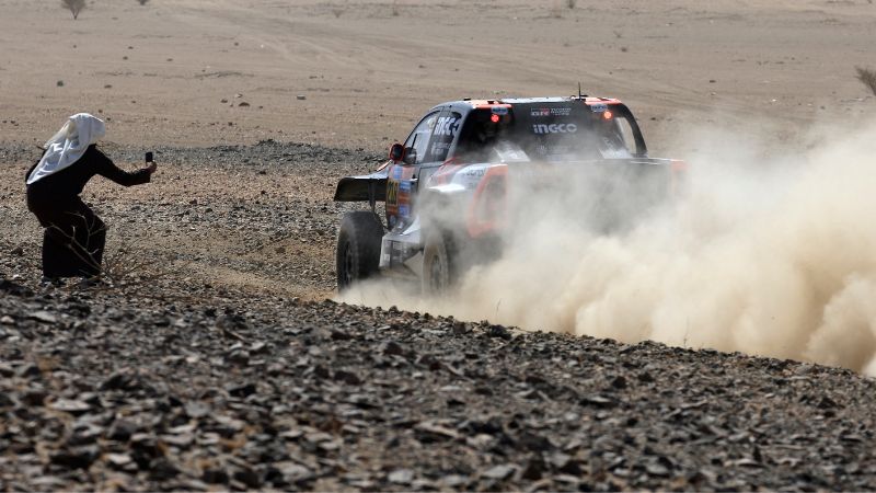 Un residente local toma fotografías del piloto Saood Variawa y el copiloto Francois Cazalet durante el prólogo del 47º Rally Dakar, en Bisha, Arabia Saudita,