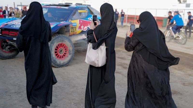 Unas mujeres fotografían el monoplaza Ford M-Sport del piloto español Nani Roma tras una sesión de entrenamientos previos al inicio del Rally Dakar 2025, en Bisha.