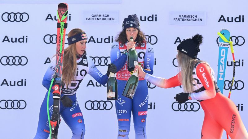 La segunda clasificada, la italiana Sofia Goggia, la ganadora, la italiana Federica Brignone, y la tercera clasificada, la suiza Corinne Suter, celebran con champán.