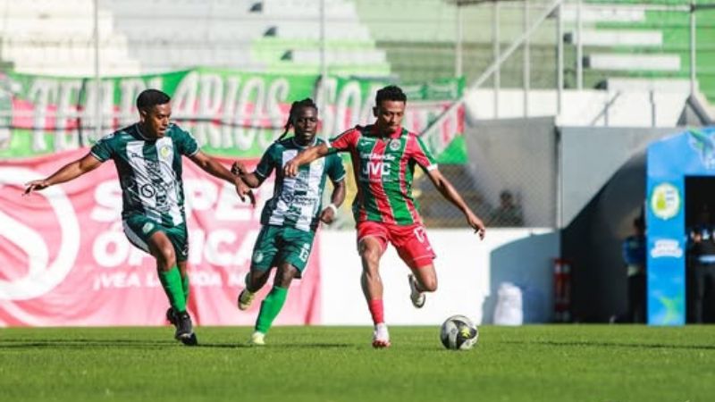 El marathonista Alexy Vega controla el balón ante las miradas de los "olanchanos", Roger González y Shalton González Arzú.