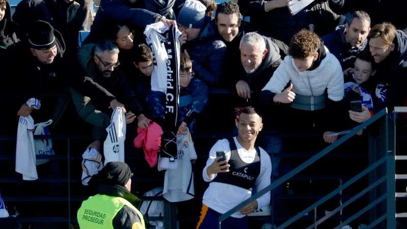 El delantero francés del Real Madrid, Kylian Mbappé, firma autógrafos y posa para fotografías con los aficionados.