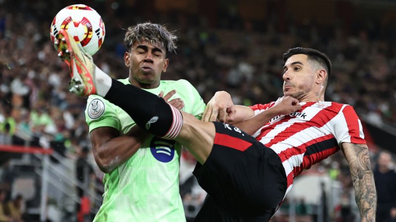 El delantero español del Barcelona, ​​Lamine Yamal, lucha por el balón con el defensa español del Athletic Bilbao, Yuri Berchiche.