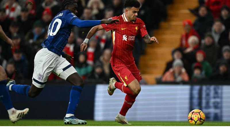 El defensa congoleño del Ipswich Town, Axel Tuanzebe, persigue al mediocampista colombiano del Liverpool, Luis Díaz.