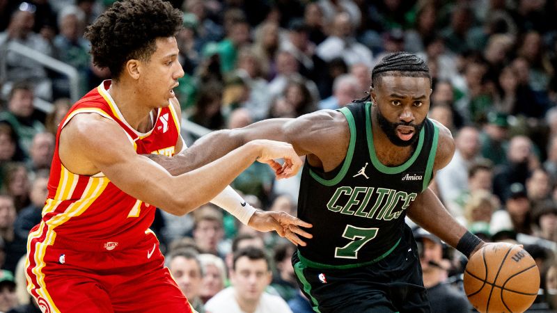 Jaylen Brown de los Boston Celtics conduce hacia la canasta contra Jalen Johnson de los Atlanta Hawks.