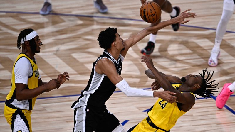 El delantero francés de los San Antonio Spurs, Victor Wembanyama, compite por el balón con el delantero estadounidense de los Indiana Pacers, Aaron Nesmith.