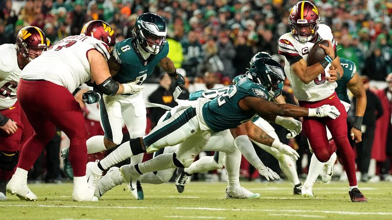 Jayden Daniels de los Washington Commanders supera a Oren Burks de los Philadelphia Eagles para anotar un touchdown.