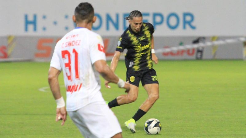 Carlos Mejía del Real España controla el balón ante la mirada de Carlos Sánchez de Olimpia.