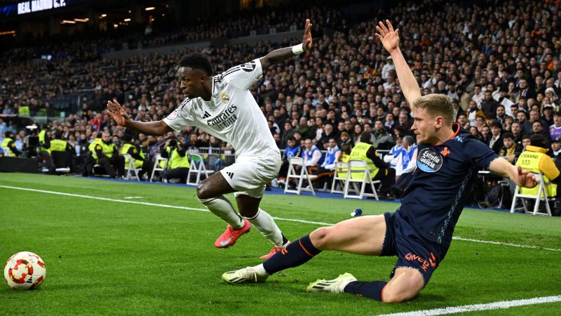 El delantero brasileño del Real Madrid Vinicius Junior lucha por el balón con el defensa sueco del Celta de Vigo Carl Starfelt.