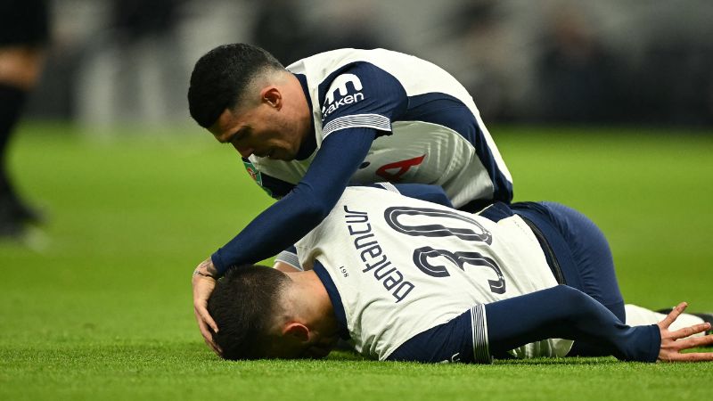 El defensa español del Tottenham Hotspur, Pedro Porro, atiende al lesionado centrocampista uruguayo, Rodrigo Bentancur.