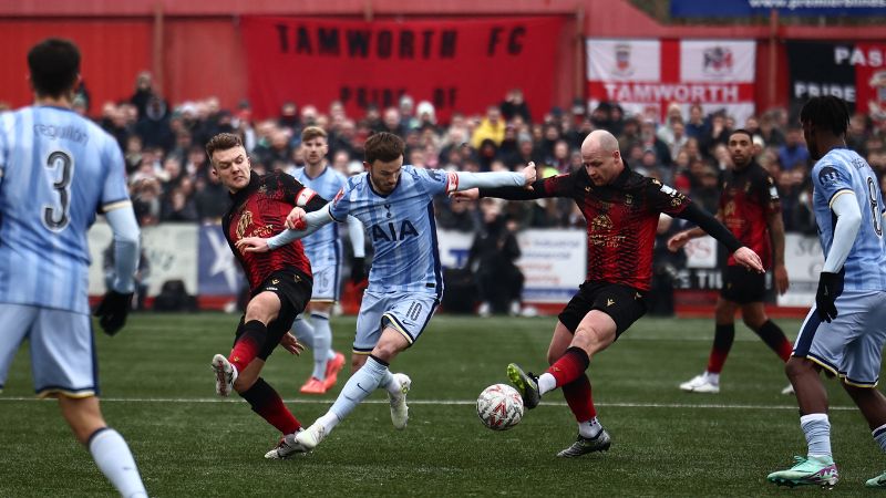 El centrocampista inglés del Tottenham Hotspur, James Maddison, compite con el futbolista del Tamworth, Tom Tonks.