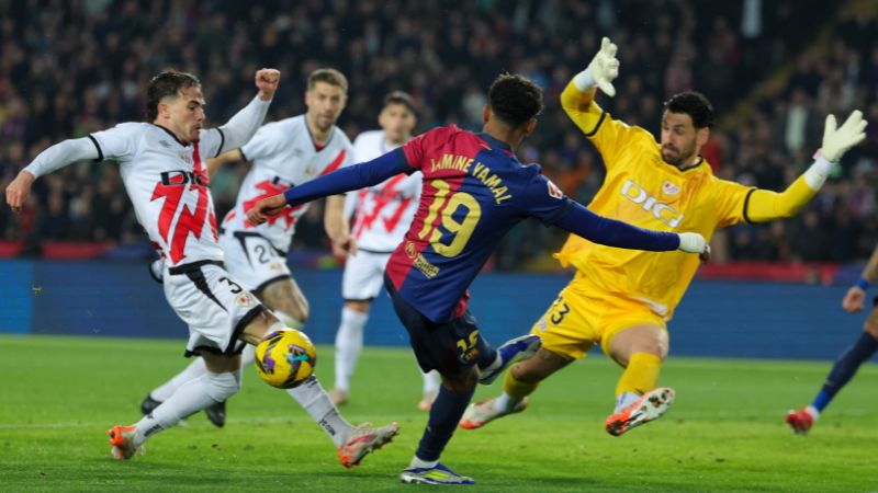 El delantero español del Barcelona Lamine Yamal es presionado por el portero argentino del Rayo Vallecano, Augusto Batalla y el defensor Pep Chavarria.