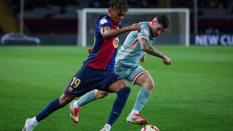 El delantero español del Barcelona, ​​Lamine Yamal, controla el balón presionado por el defensa español del Atlético de Madrid, Javi Galán.