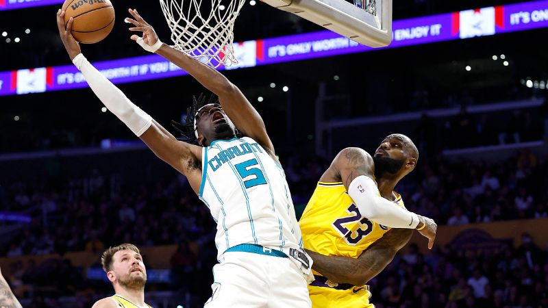 LeBron James, de Los Angeles Lakers, trata de evitar el enceste de Mark Williams, de los Charlotte Hornets.