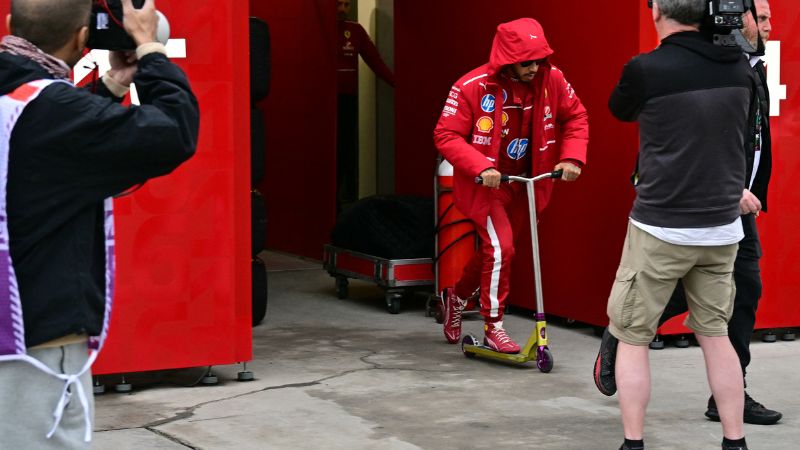 El piloto británico de Ferrari, Lewis Hamilton, conduce un scooter en el segundo día de pruebas de pretemporada de Fórmula 1.