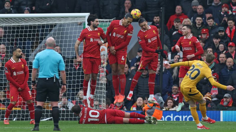 El defensa holandés del Liverpool, Virgil van Dijk, desvía con la cabeza un tiro libre del centrocampista inglés del Wolverhampton Wanderers Tommy Doyle.