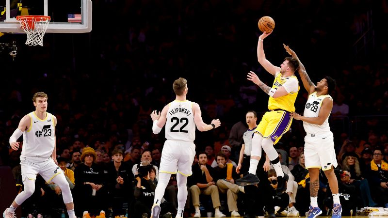 Luka Doncic de Los Angeles Lakers lanza el balón sobre Brice Sensabaugh y Kyle Filipowski de Utah Jazz.