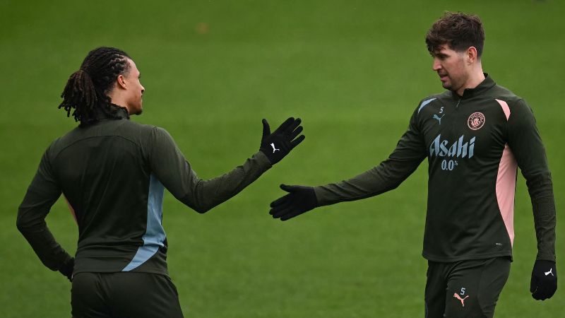 El defensa holandés del Manchester City, Nathan Ake, estrecha la mano de su compañero, John Stones, durante el entrenamiento.