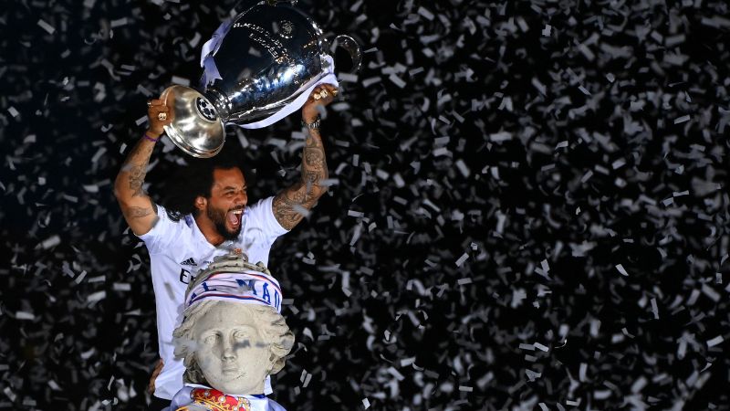 En la foto de archivo, el defensa brasileño del Real Madrid, Marcelo, levanta el trofeo sobre la estatua de la diosa griega Cibeles.