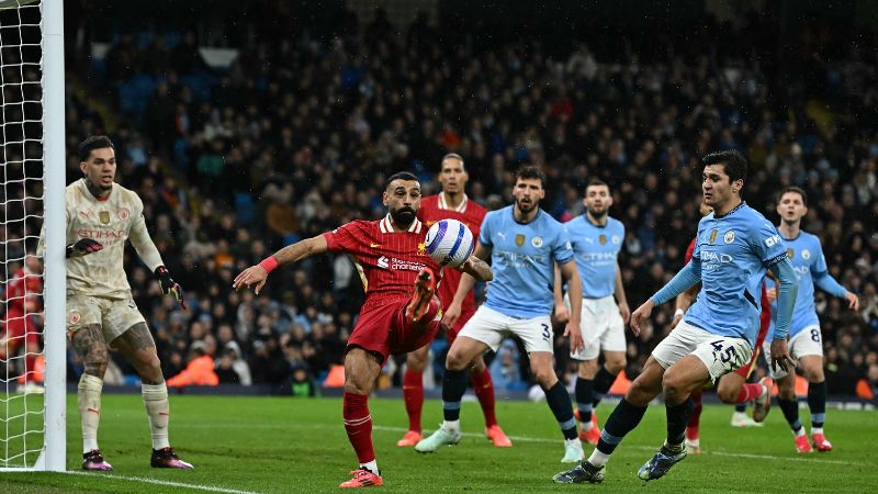 El delantero egipcio del Liverpool, Mohamed Salah, defiende el balón del defensor uzbeko del Manchester City, Abdukodir Khusanov.