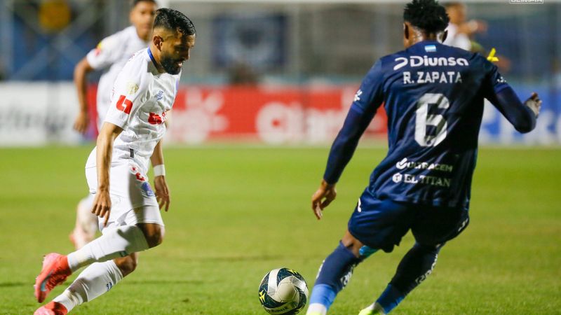 El mediocampista de Olimpia, Jorge Álvarez, enfrenta al defensa de Motagua, Ricky Zapata.