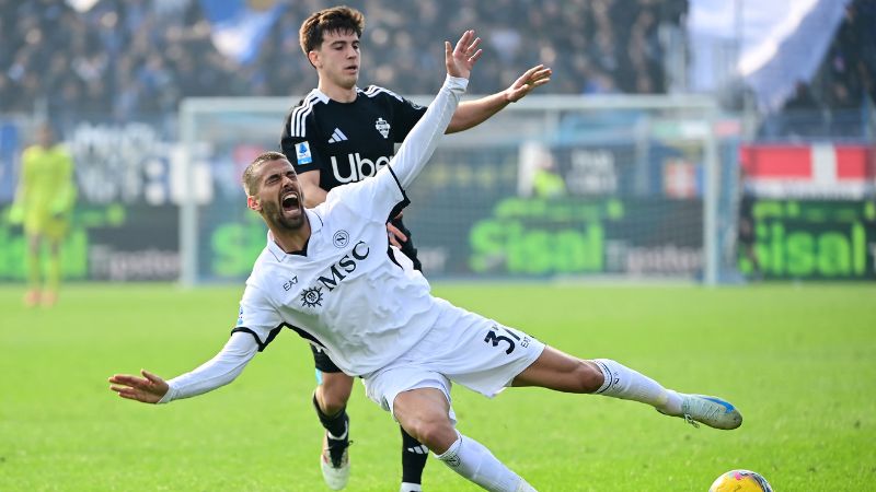 El defensa italiano del Nápoles, Leonardo Spinazzola, reacciona mientras lucha por el balón con el mediocampista argentino del Como, Maximo Perrone.