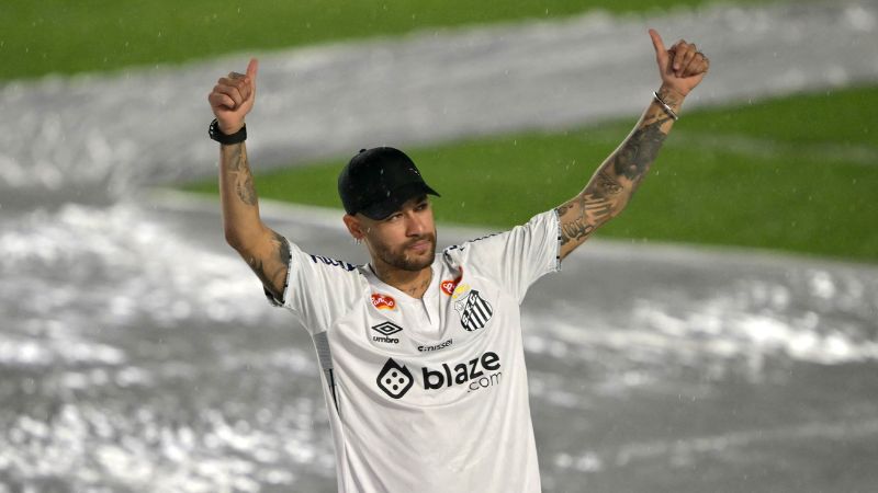 El astro del fútbol brasileño Neymar hace un gesto con el pulgar hacia arriba ante los fanáticos durante su presentación.