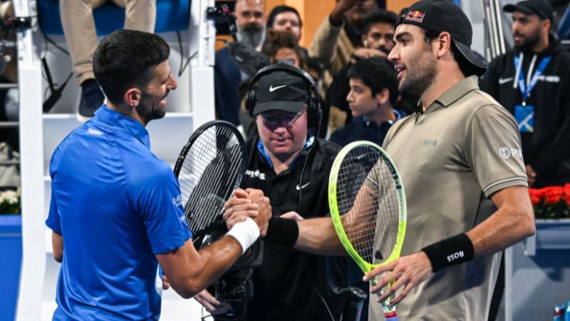 El italiano Matteo Berettin estrecha la mano del serbio Novak Djokovic después de su partido individual en el torneo de tenis ATP Qatar Open en Doha.