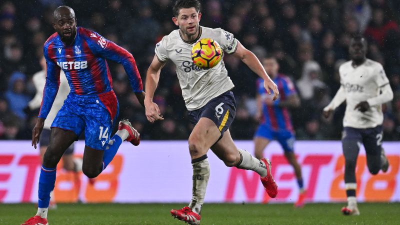 El delantero francés del Crystal Palace, Jean-Philippe Mateta y el defensa inglés del Everton, James Tarkowski, miran el balón.