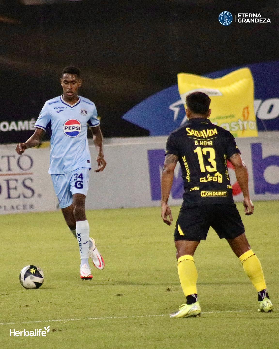 Giancarlo Sacaza de Motagua controla el balón ante la mirada del españolista, Brayan Moya.