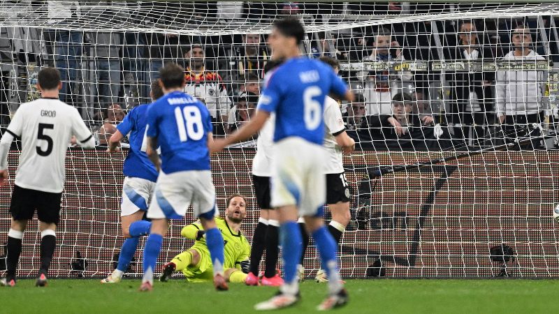 El delantero italiano Moise Kean marca el 3-2 ante el portero alemán Oliver Baumann.