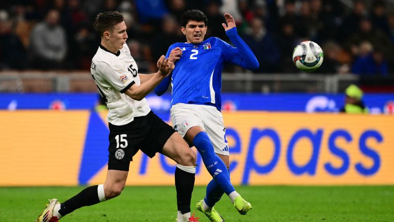 El defensa alemán Nico Schlotterbeck lucha por el balón con el defensa italiano Raoul Bellanova.