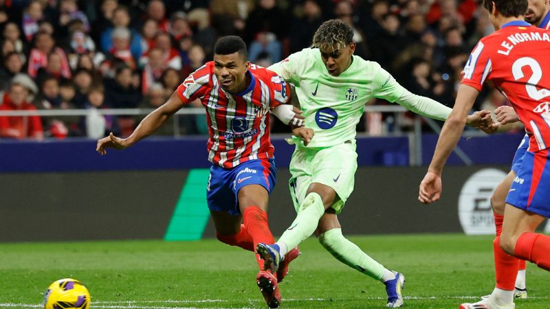 El defensa mozambiqueño del Atlético de Madrid, Reinildo Mandava, lucha por el balón con el delantero español del Barcelona, ​​Lamine Yamal.