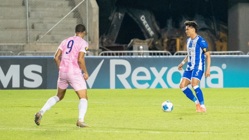 El capitán hondureño, Denil Maldonado, controla el balón ante la mirada de Enrique Rusell de Bermudas.