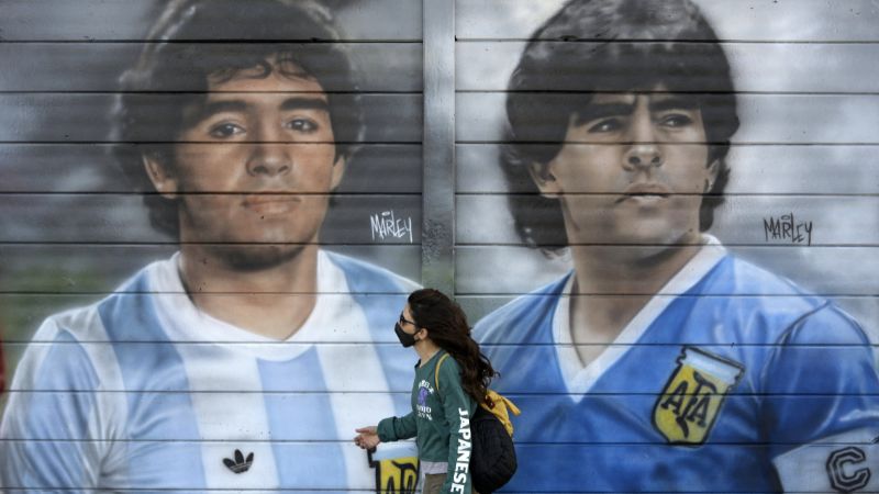 En la foto de archivo, una persona pasa junto a murales pintados por el artista Marley en el exterior del estadio Diego Armando Maradona.