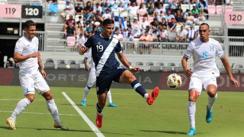 El guatemalteco José Martínez busca controlar el balón ante la mirada de los hondureños, Marcelo Santos y Devron García.