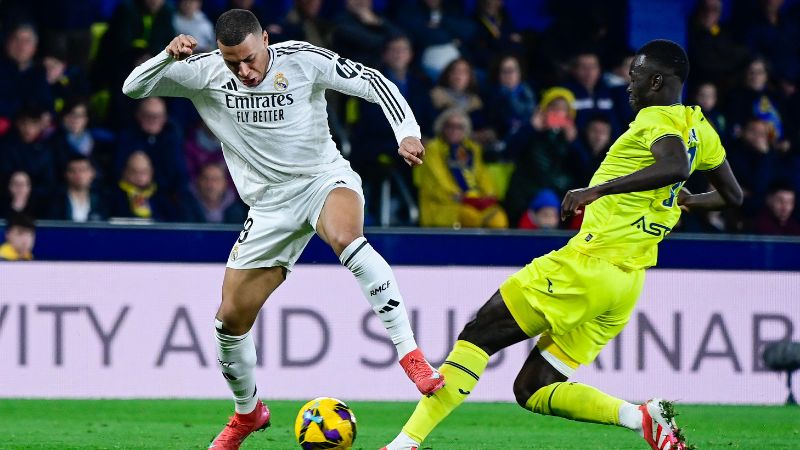 El delantero francés del Real Madrid, Kylian Mbappé, controla el balón ante la marca del centrocampista senegalés del Villarreal, Pape Gueye.