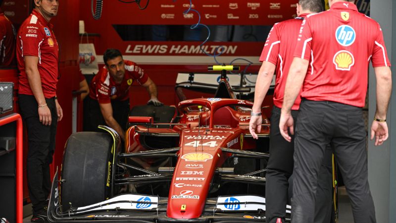 Mecánicos trabajan en el monoplaza del piloto británico de F1 de Ferrari, Lewis Hamilton, en el circuito Albert Park de Melbourne.