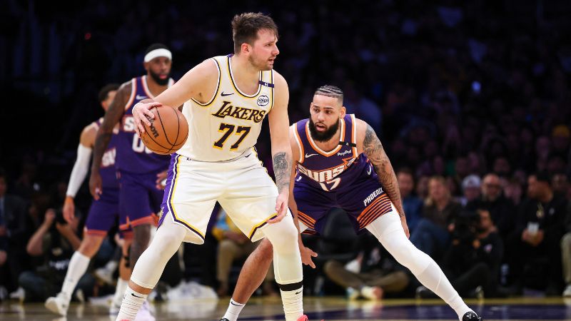 Luka Doncic de Los Angeles Lakers es presionado en media cancha por Cody Martin de los Phoenix Suns.