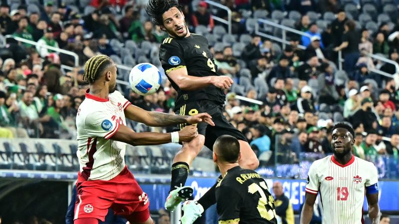 El delantero mexicano Raúl Jiménez cabecea el balón superando al defensor canadiense Derek Cornelius.