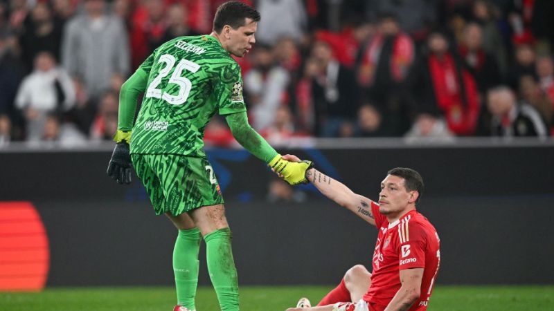 El portero polaco del Barcelona, ​​Wojciech Szczesny, ayuda al delantero italiano del Benfica, Andrea Belotti.