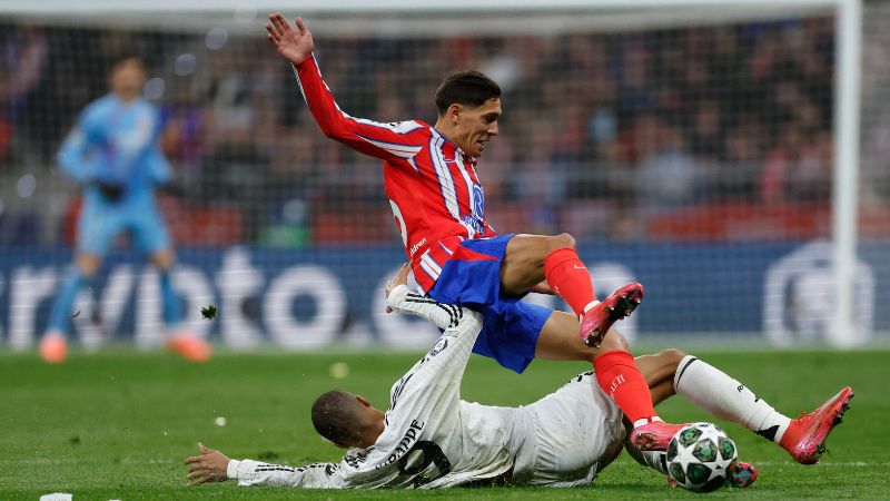 El defensa argentino del Atlético de Madrid, Nahuel Molina Lucero, disputa el balón con el delantero francés del Real Madrid, Kylian Mbappé.