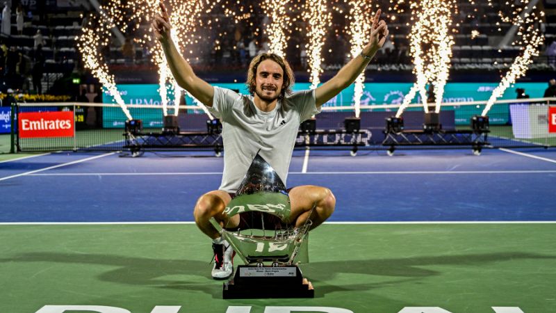 El griego Stefanos Tsitsipas celebra con el trofeo en el podio después de ganar el partido final del ATP Dubai Duty Free Tennis Championship.