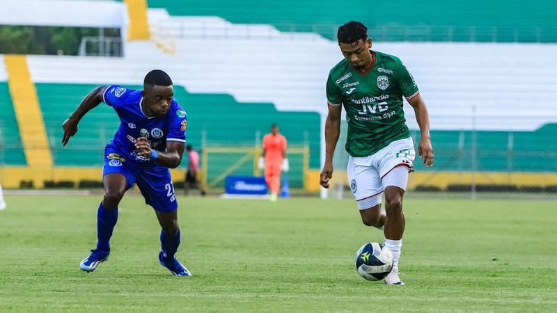 Alexy Vega, de Marathón, conduce el balón ante la marca de Wisdom Quayé, de Victoria.