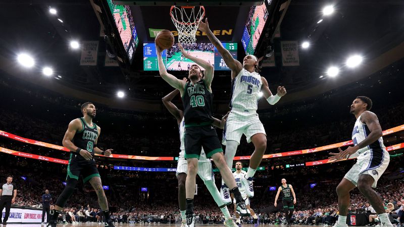 Luke Kornet de los Boston Celtics lanza contra Paolo Banchero de los Orlando Magic.