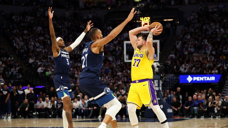 Luka Doncic de Los Ángeles Lakers busca pasar el balón frente a Jaden McDaniels y Rudy Gobert de los Minnesota Timberwolves.