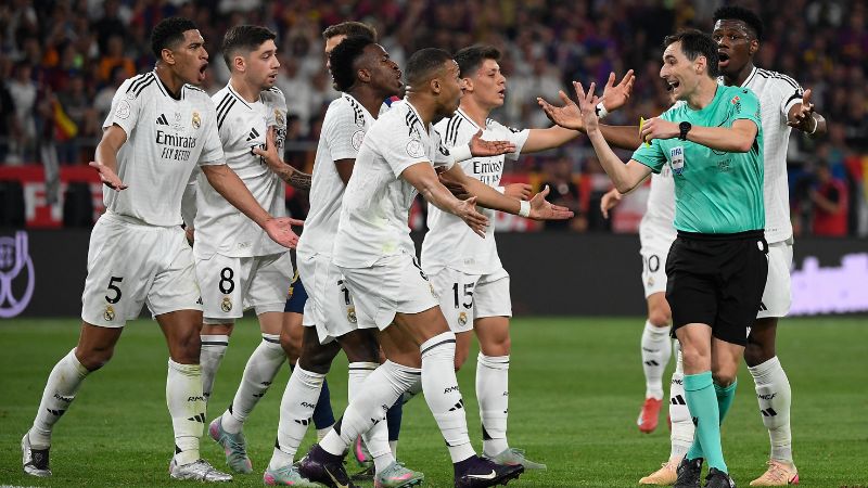 Los jugadores del Real Madrid protestan con el árbitro español Ricardo De Burgos Bengoetxea.