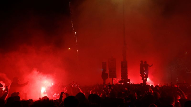 Los aficionados del Paris Saint-Germain (PSG) encienden bengalas frente al Estadio Parque de los Príncipes de París.